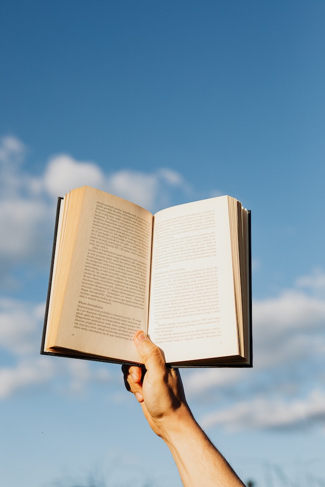 Personne avec un livre au soleil.