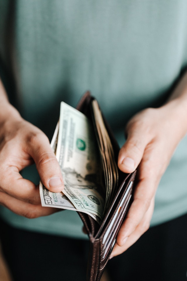 Hombre sacando dinero de su cartera.