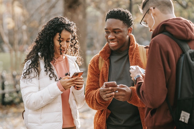 Groep van drie vrienden op hun telefoons.