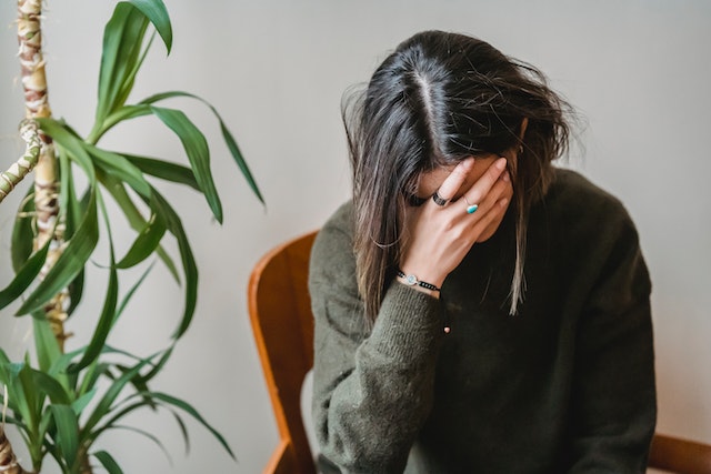 Woman facepalms as she stares at her mistake.