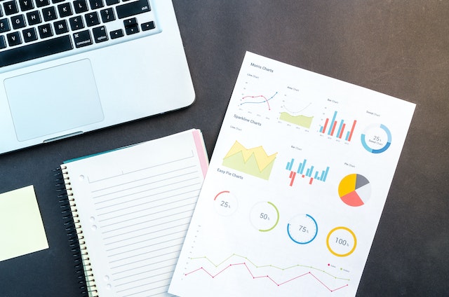 Documents showing graphs and laptop.
