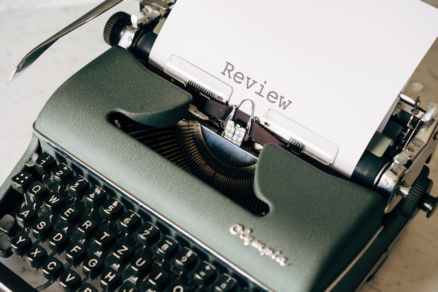 A piece of paper saying "review" comes from a typewriter.