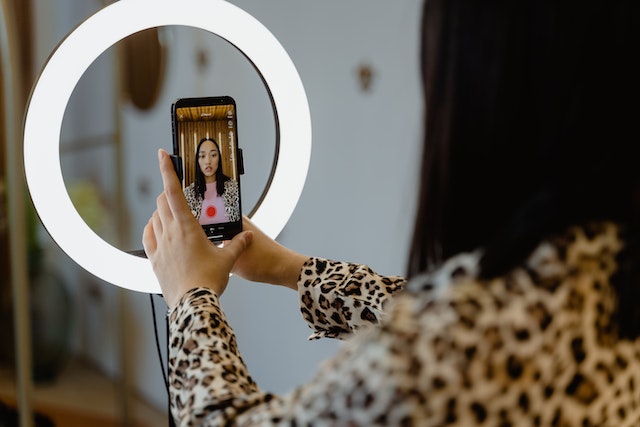 Mulher a utilizar um anel luminoso para vídeos de alta qualidade em Instagram Reels.