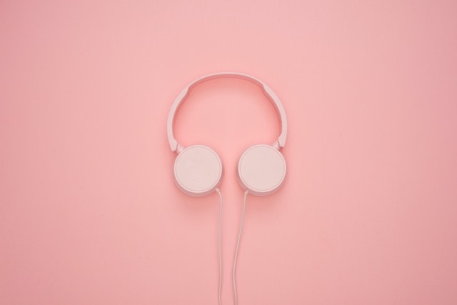 Pink headphones against a pink background
