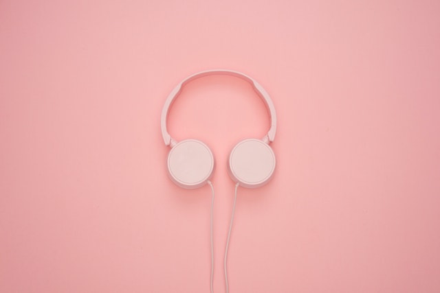 Auriculares rosas sobre fondo rosa.