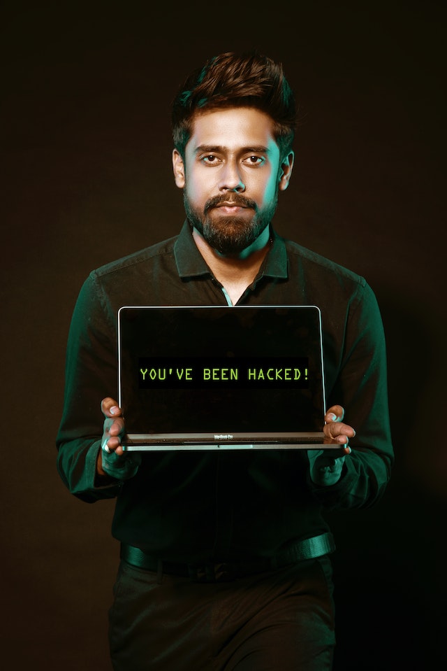 Homem a segurar um computador portátil com as palavras &quot;You&#039;ve been hacked!