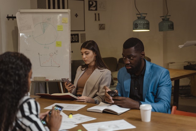 Des collègues de travail lisent les commentaires Instagram sur le lancement récent d'un produit.