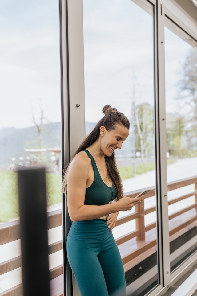 Frau lacht über einen Instagram Reel, den ihr Freund ihr geschickt hat.