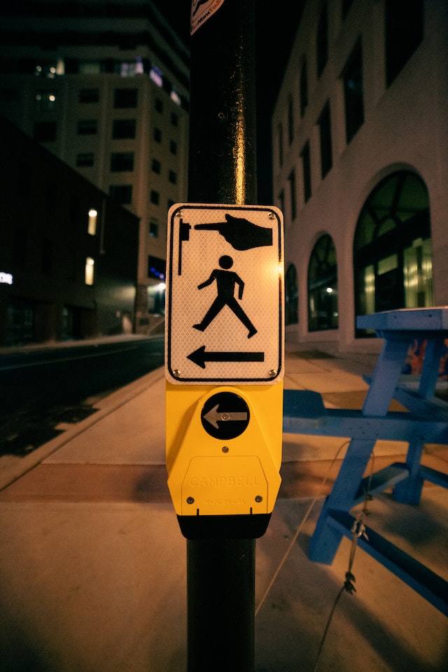 Sign at night for pedestrians to cross the road. 