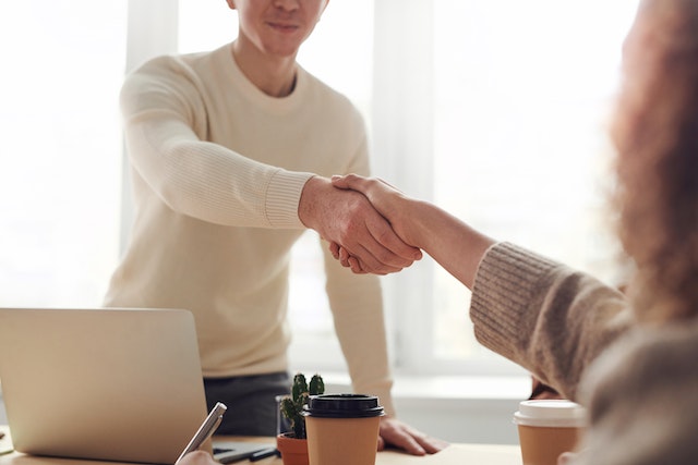 De maker van UGC schudt de hand van een klant nadat hij zijn eerste baan heeft binnengehaald.