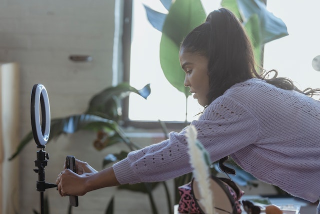 pexels-george-milton-6954087 | Path Social Eine Frau stellt ihr Telefon senkrecht auf, um die richtige Videogröße für Reels zu erhalten.