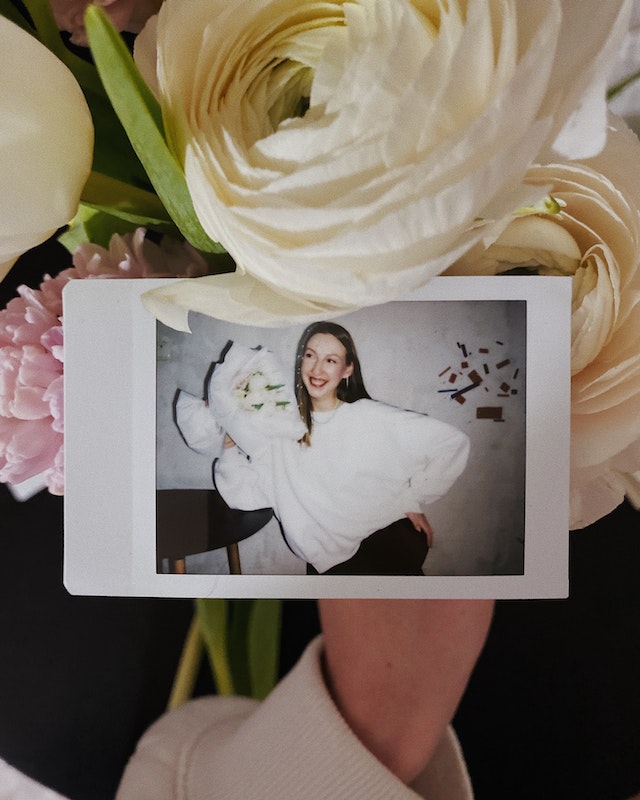 pexels-kateryna-hnidash-15988623 | Path Social 부케를 들고 있는 여성의 폴라로이드 사진.