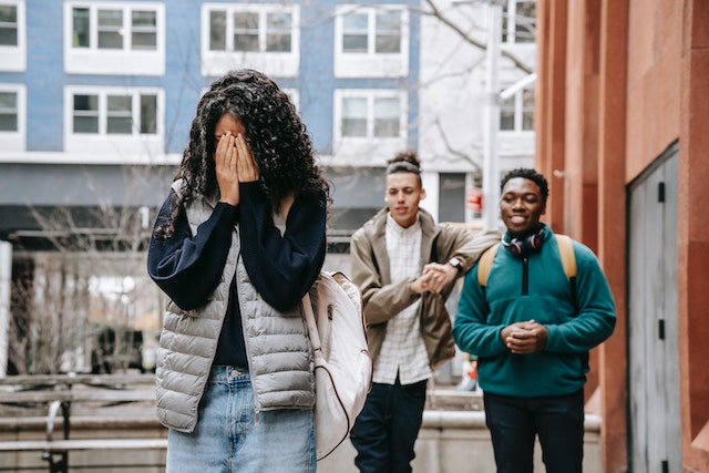 Teenage girl being bullied by her peers.