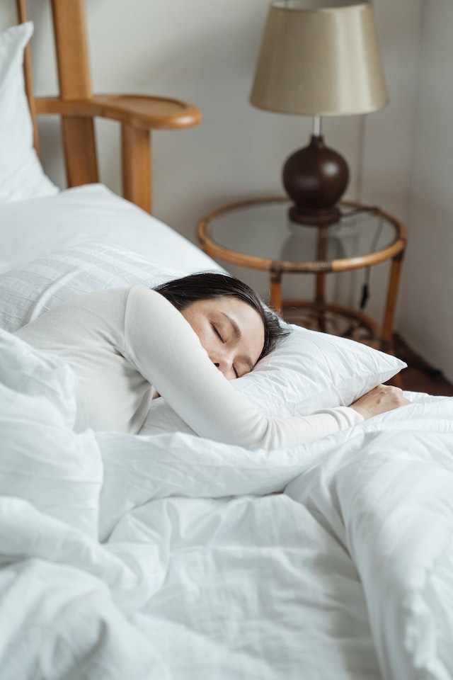 Giovane donna che dorme in un comodo letto.