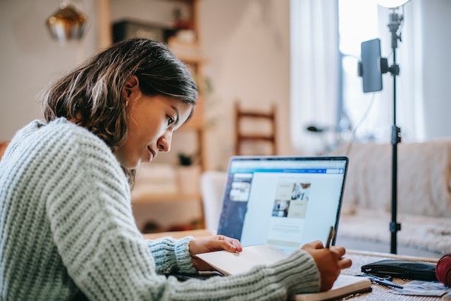 Tiener die zich op huiswerk concentreert tijdens haar geplande Instagram breken.