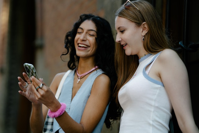 Deux amis qui rient ensemble après avoir vu un message drôle et réaliste sur Instagram .