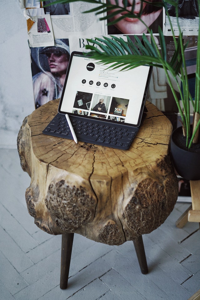 iPad showing Instagram highlights with a keyboard on a wooden table.