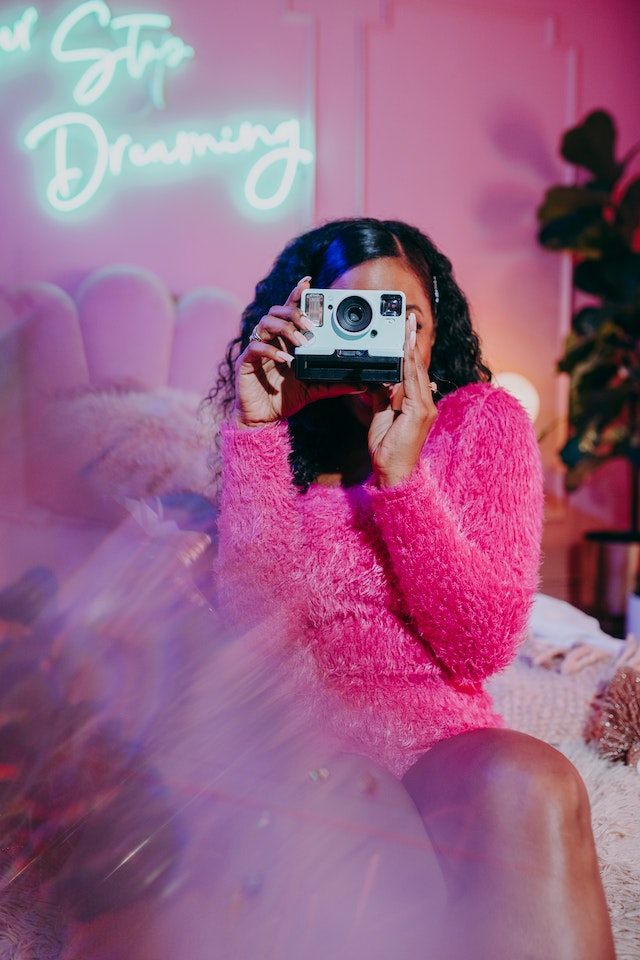 Una ragazza che scatta foto con un'estetica smaccatamente rosa e femminile.