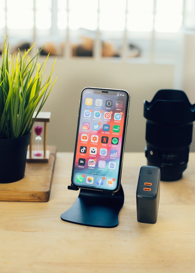 pexels-screen-post-4526429 | Path Social Smartphone auf dem Schreibtisch in der Nähe des Netzteils und der Kameralinse