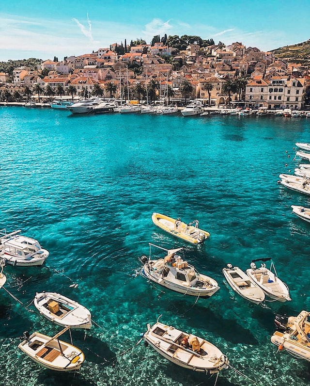 White boats on a body of water with the coastline in the background.