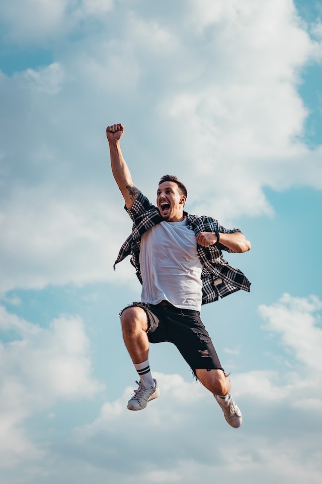 pexels-vlad-chetan-2923156 | Path Social Image of a man jumping into the air with clouds behind him.