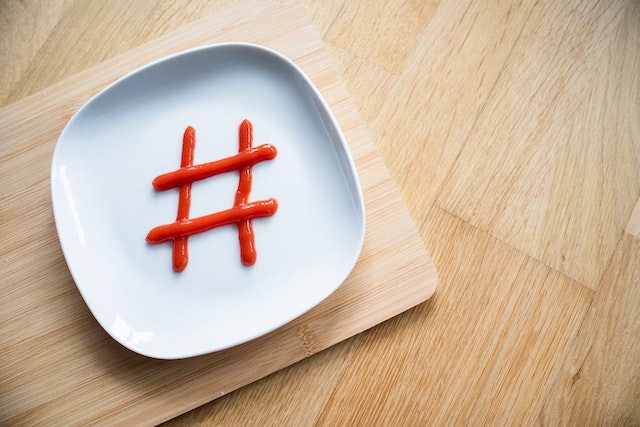 Simbol Hashtag realizat din ketchup pe o farfurie albă.