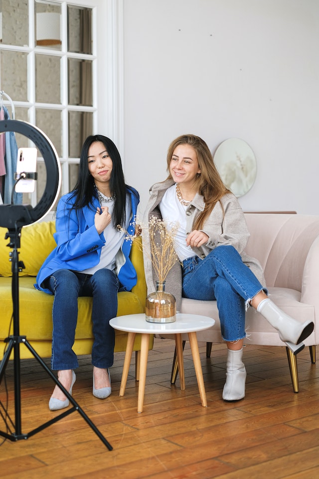 pexels-anna-shvets-6593780 | Path Social Due donne che filmano contenuti per Instagram usando il loro telefono su un treppiede e un anello luminoso.