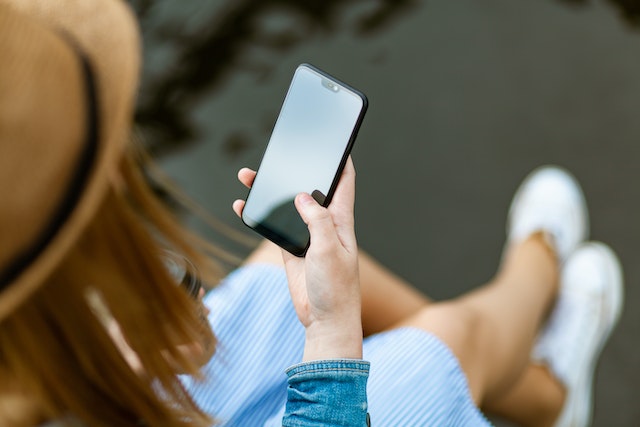 Person holding smartphone while sitting.