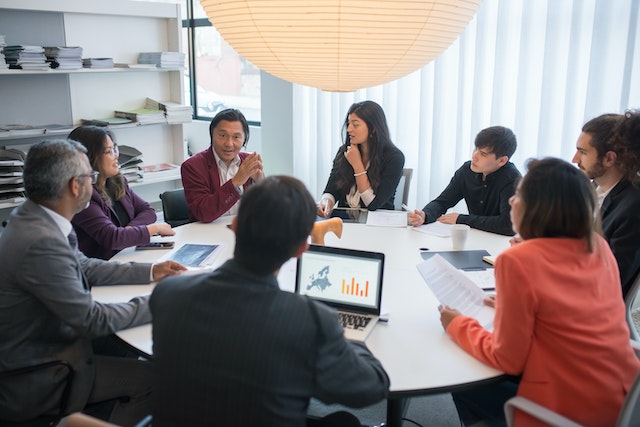 pexels-kampus-production-8190804 | Path Social Eight people sitting at a round table during a work meeting.