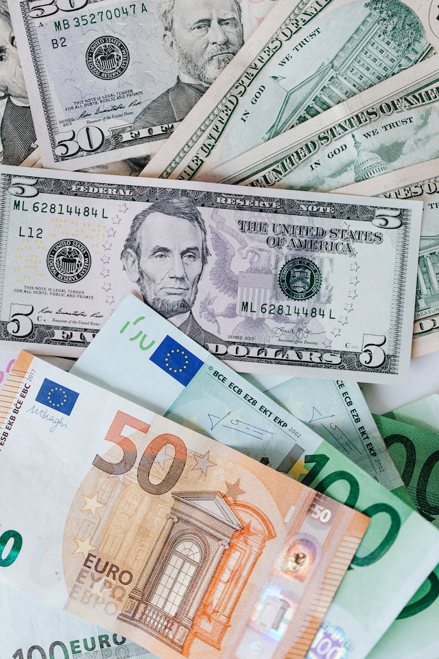 Stack of different currency with a photo of men and buildings.