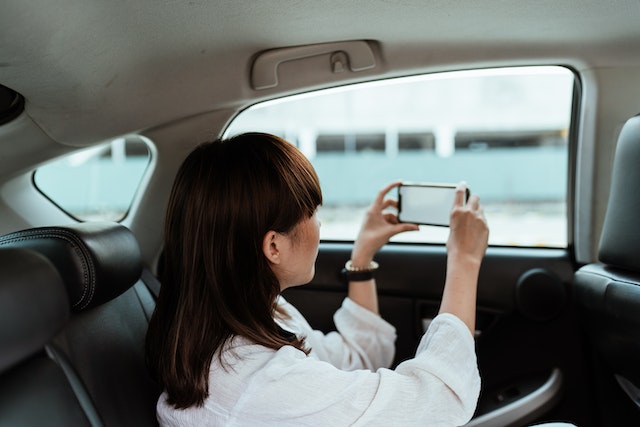 車窓越しに写真を撮る女性。