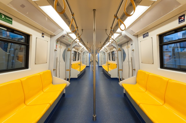 Treno della metropolitana vuoto con sedili giallo brillante.