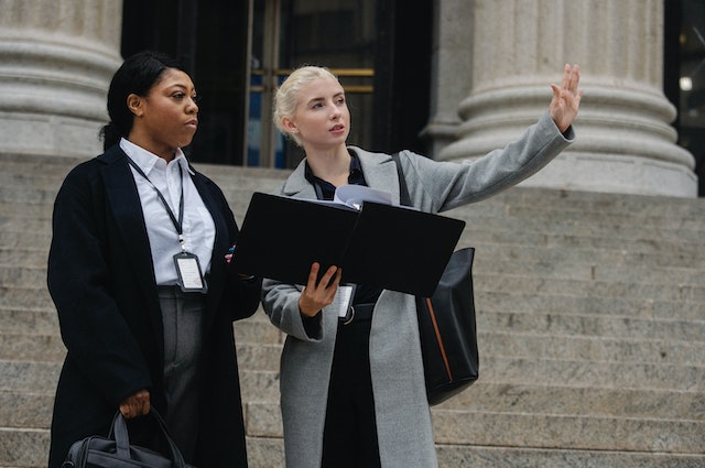 Formal businesswomen with document discussing city management