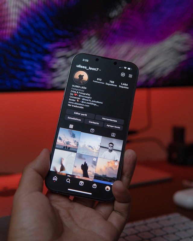 Persona invisible que sostiene un smartphone en la pantalla de perfil de Instagram .