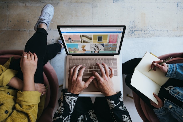 Drie mensen werken op een laptop