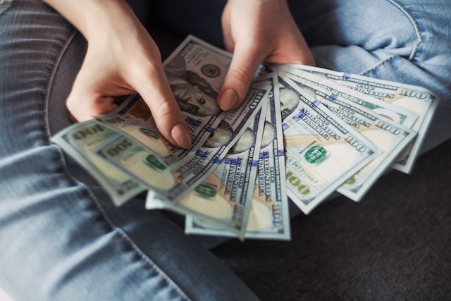 A woman counting 100-dollar bills.