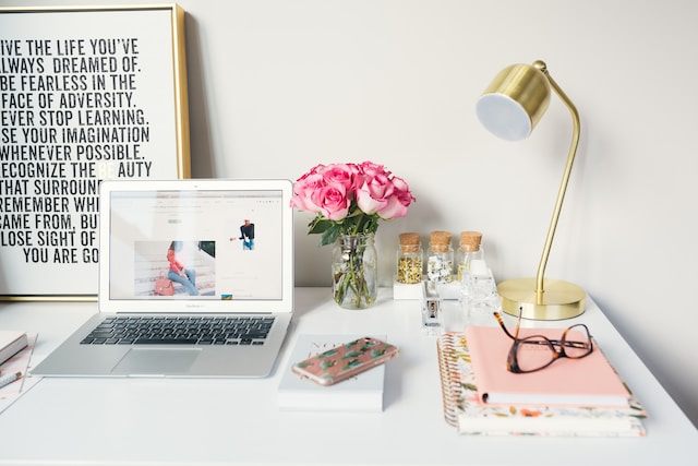 View of a working space with a laptop, phone, glasses, and notebook