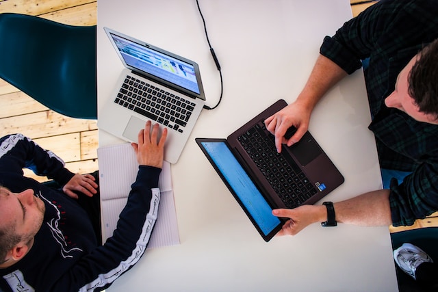 twee mannen werken aan laptops 