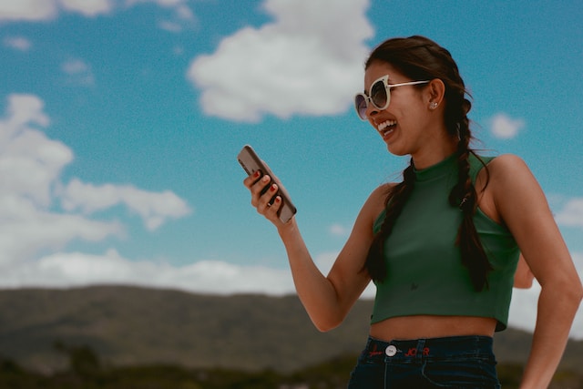 A woman smiling at her phone