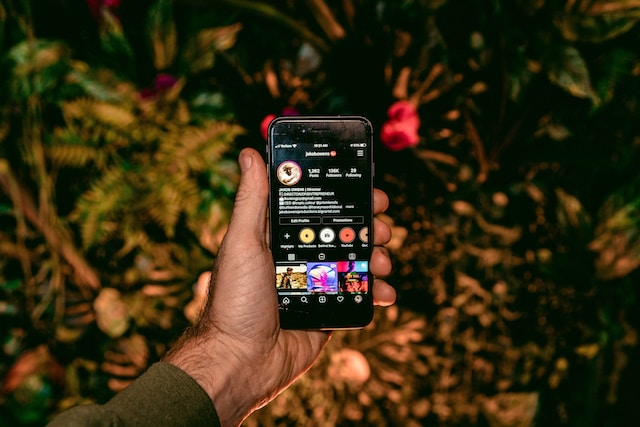 jakob-owens-50LI_TgaB3k-unsplash | Path Social A person is holding a phone opening a profile of a social media influencer with 136K following