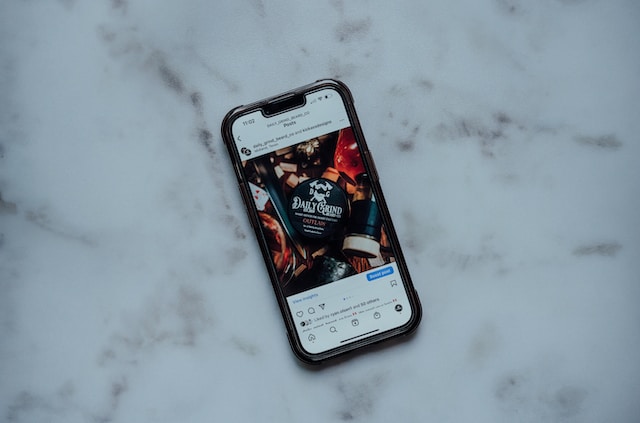 lance-reis-PXXrJIValFs-unsplash | Path Social A cell phone on a white table displaying a post selling on Instagram