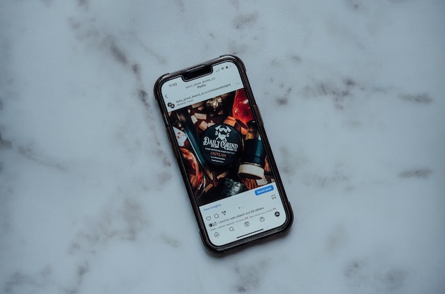 A cell phone on a white table displaying a post selling on Instagram