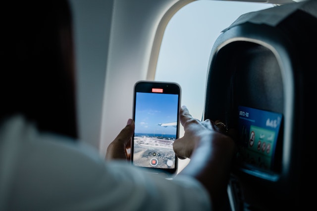 Una ragazza che scatta foto da un aereo.