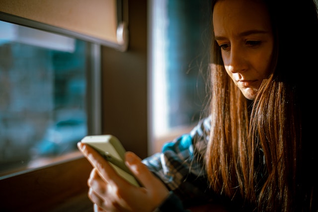 Una influencer tomando medidas para conocer a sus seguidores de Instagram en su teléfono móvil. 