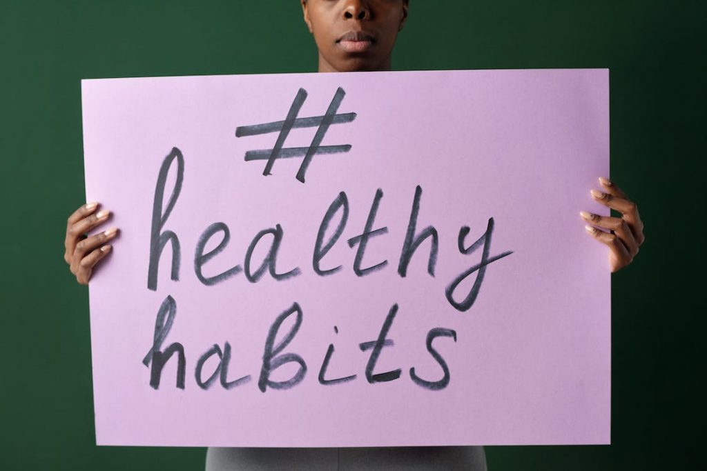 A woman holding a poster with a hashtag