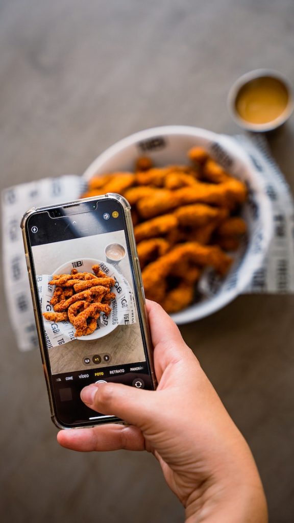 Persona non vista che fotografa il cibo con il proprio telefono per il marketing del prodotto.