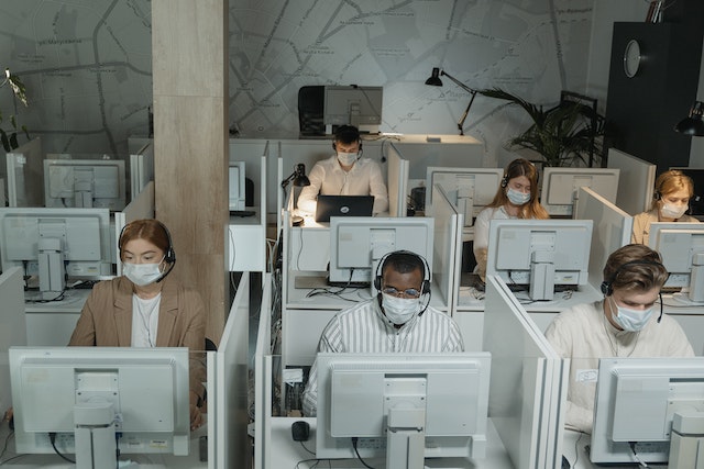 Ein Kundenserviceteam bei der Arbeit mit Gesichtsmasken. 