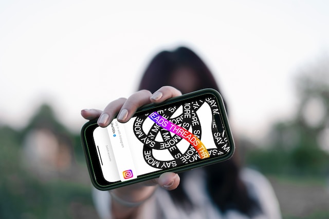 viralyft-nysnJ3xzLcM-unsplash | Path Social A person holding a smartphone that shows the Threads app.
