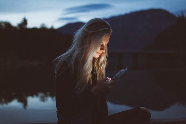 becca-tapert-QofjUnxy9LY-unsplash | Path Social Jemand schaut sich auf seinem Handy die Familienfotos von Kim Kardashian auf Instagram an.