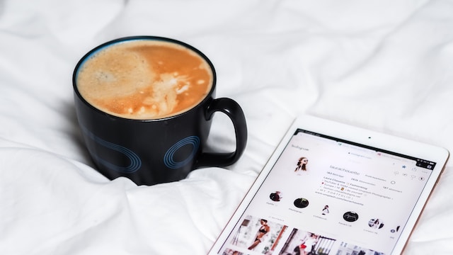 Kaffee neben einem Tablet mit Instagram , das für einen Nutzer geöffnet ist, der gerade seine Instagram einsehen will.